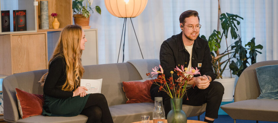 Moderatorin Anabelle Stehl und Sänger Batomae sitzen auf der Couch bei den tolino StoryDays.
